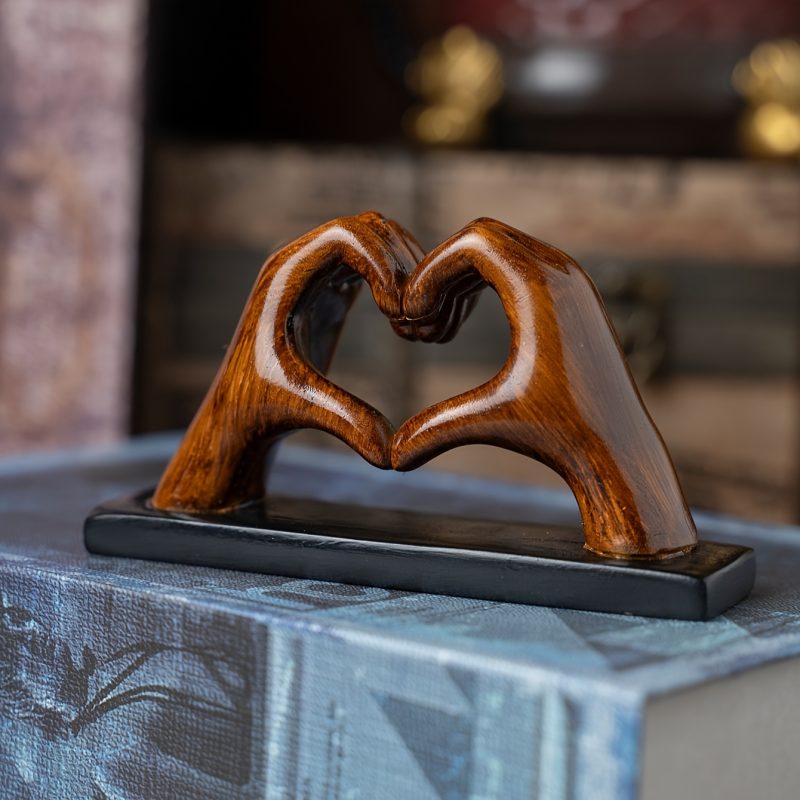 Statuette da collezione, una piccola statuetta decorativa di due mani che formano un cuore,