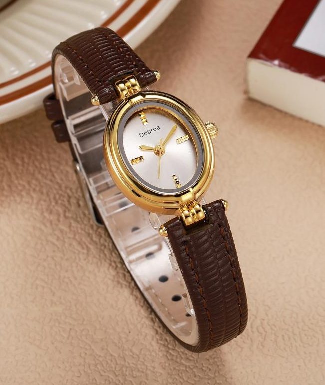 Orologio vintage da donna, piccolo e rotondo, con un design elegante e artistico, caratterizzato da un quadrante minimalista e una cinturino in ecopelle di lusso leggero, che soddisfa i gusti di nicchia.